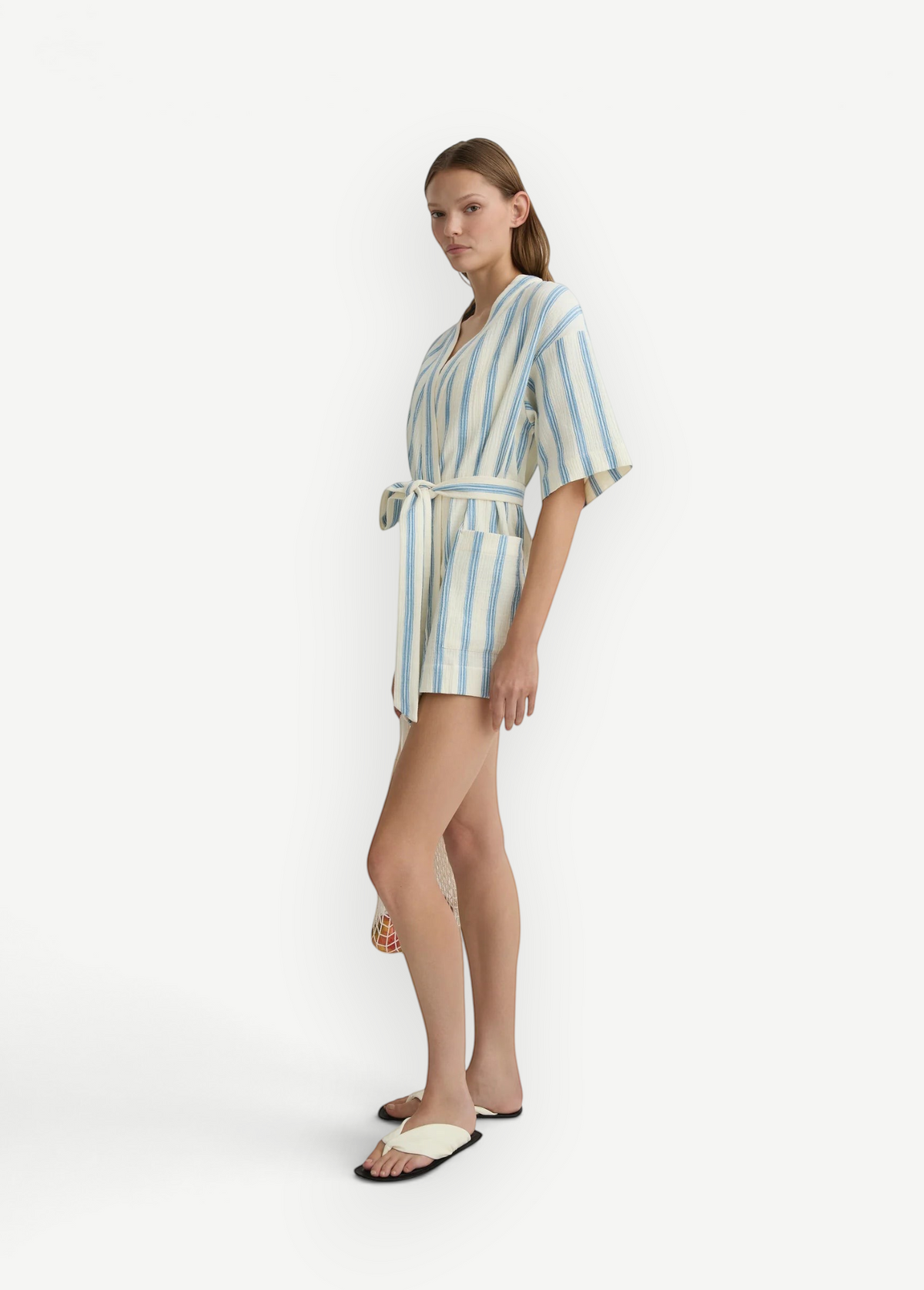 Model wearing KABE SHOP INC Finn wrap tunic in white and blue striped lightweight fabric with a waist tie