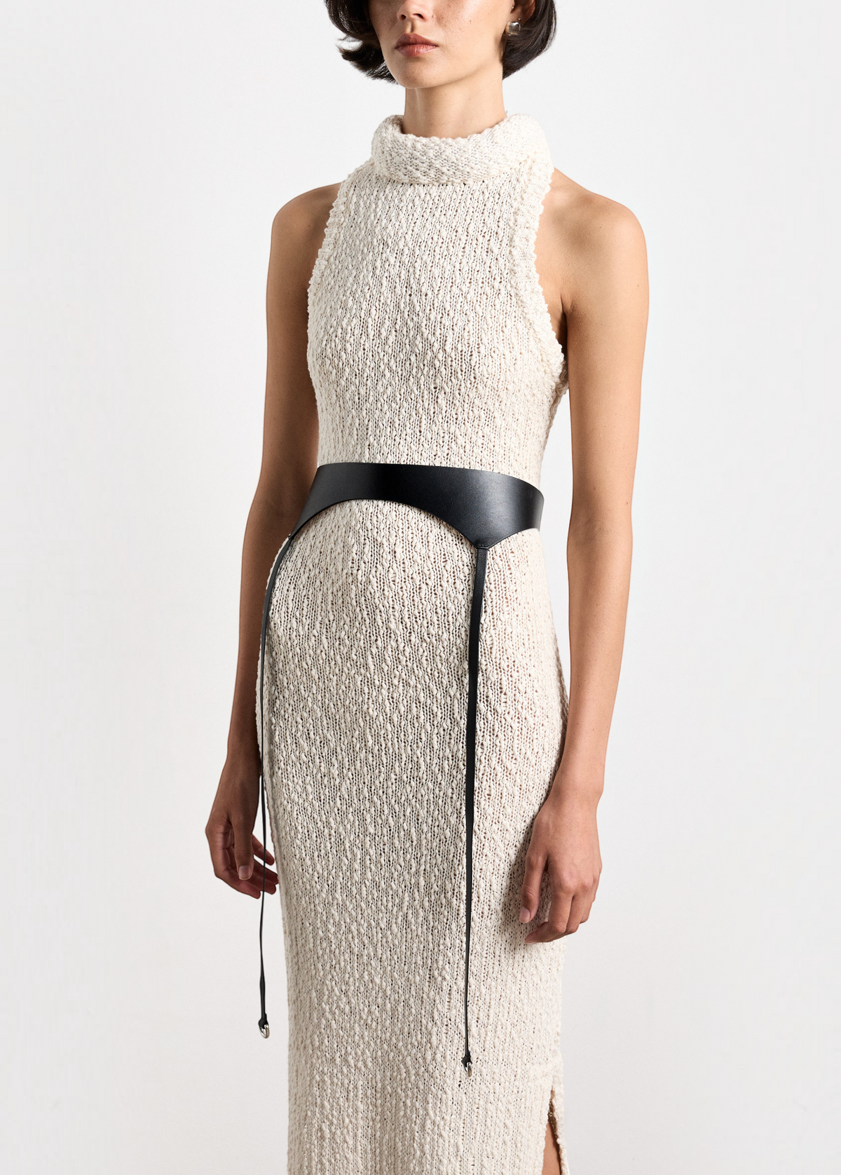 Model wearing KABE SHOP INC Laisse black Italian calfskin garter belt over a textured cream knit sleeveless dress