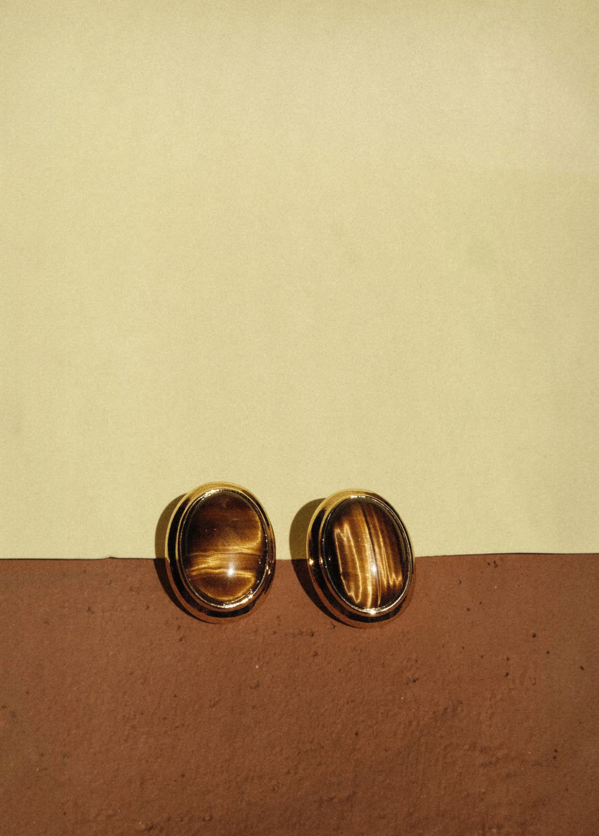 KABE SHOP INC oval cat-eye earrings featuring polished brown tiger eye stones in gold-tone settings.