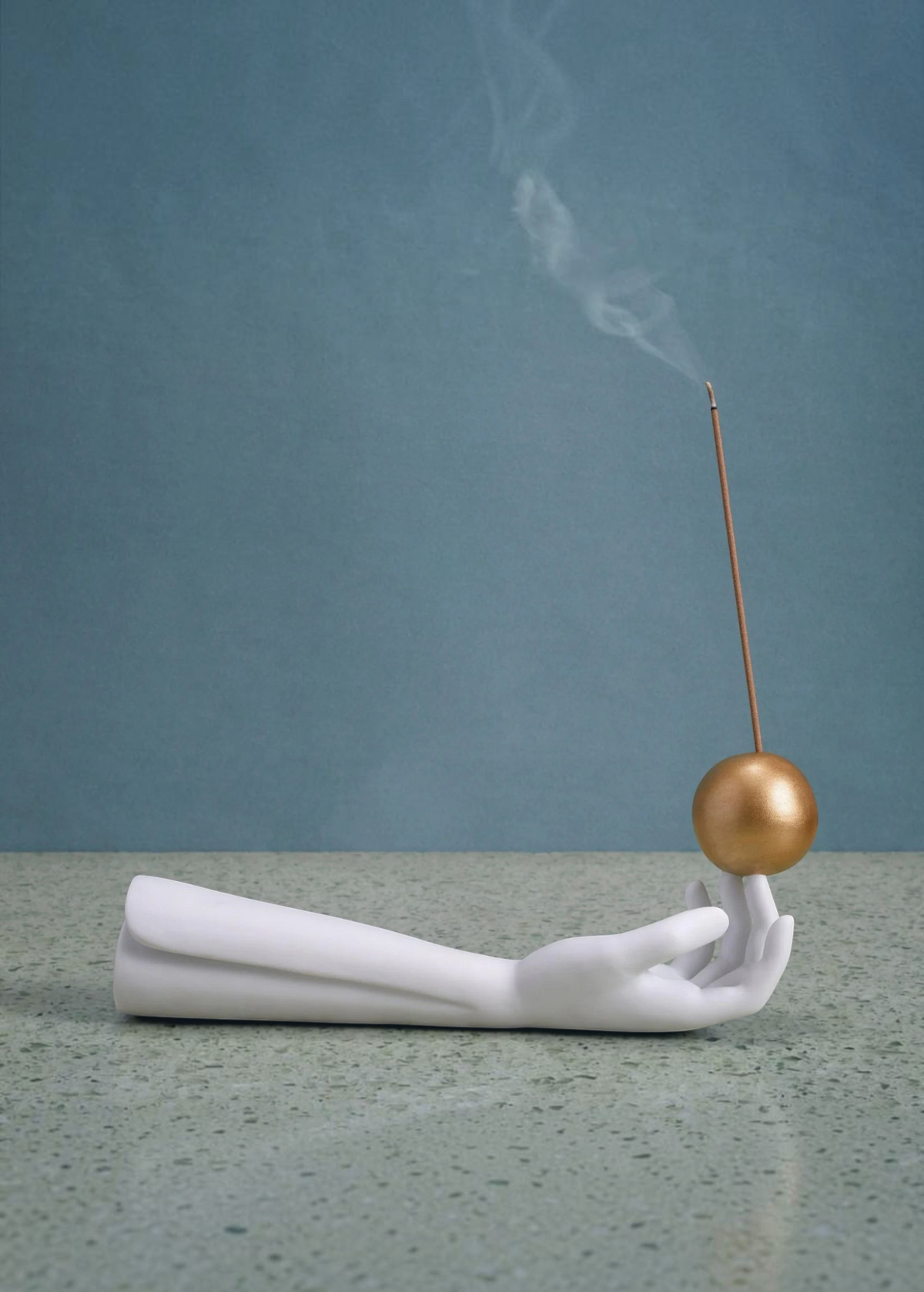 KABE SHOP INC Atlas porcelain incense holder featuring a white hand sculpture balancing a gold sphere with incense