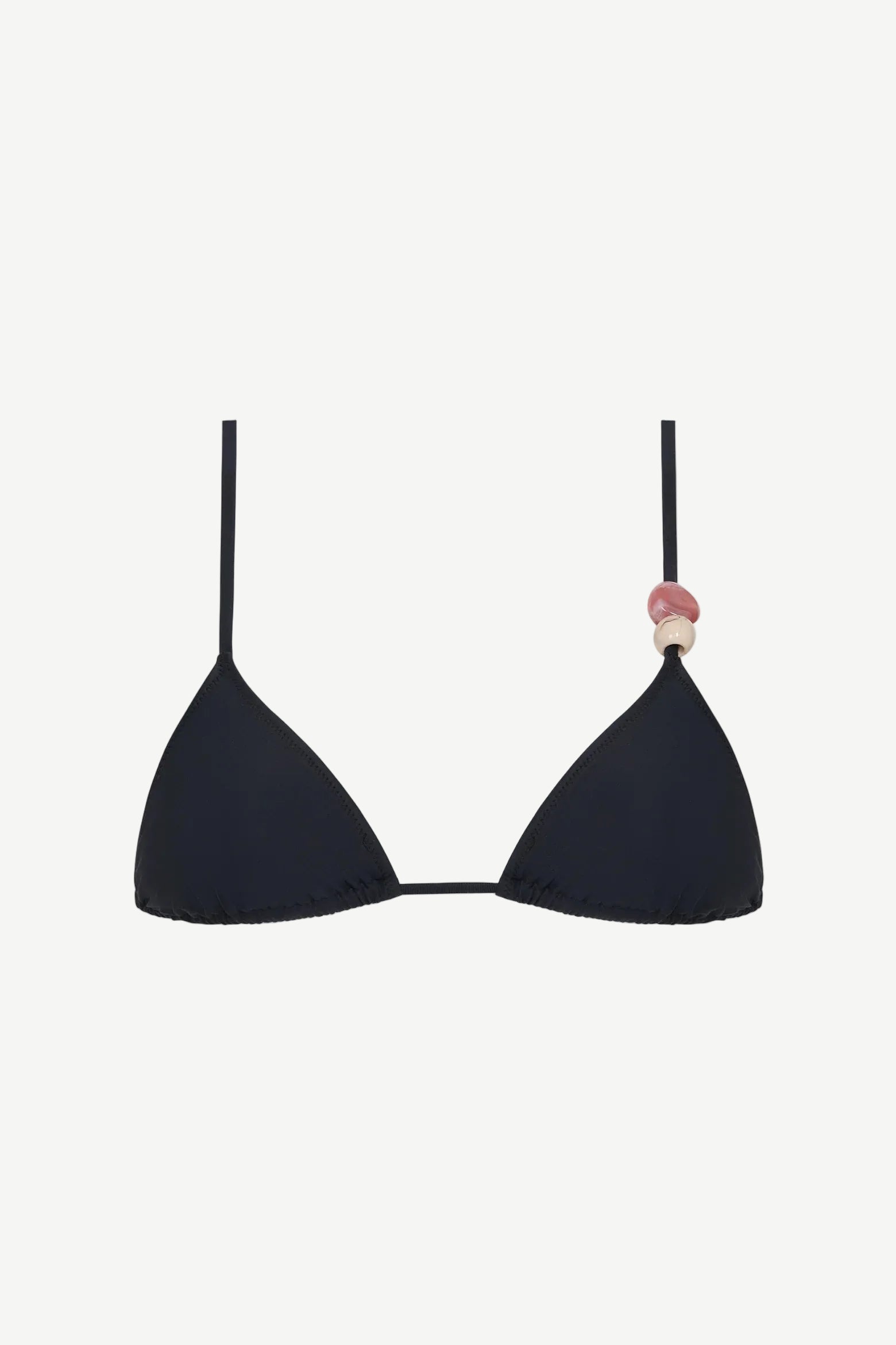The Equator Top is a black triangle bikini top with a classic silhouette, made from eco-friendly recycled polyamide swimwear fabric. It features a pink and beige decorative bead on one strap and is shown against a plain white background.
