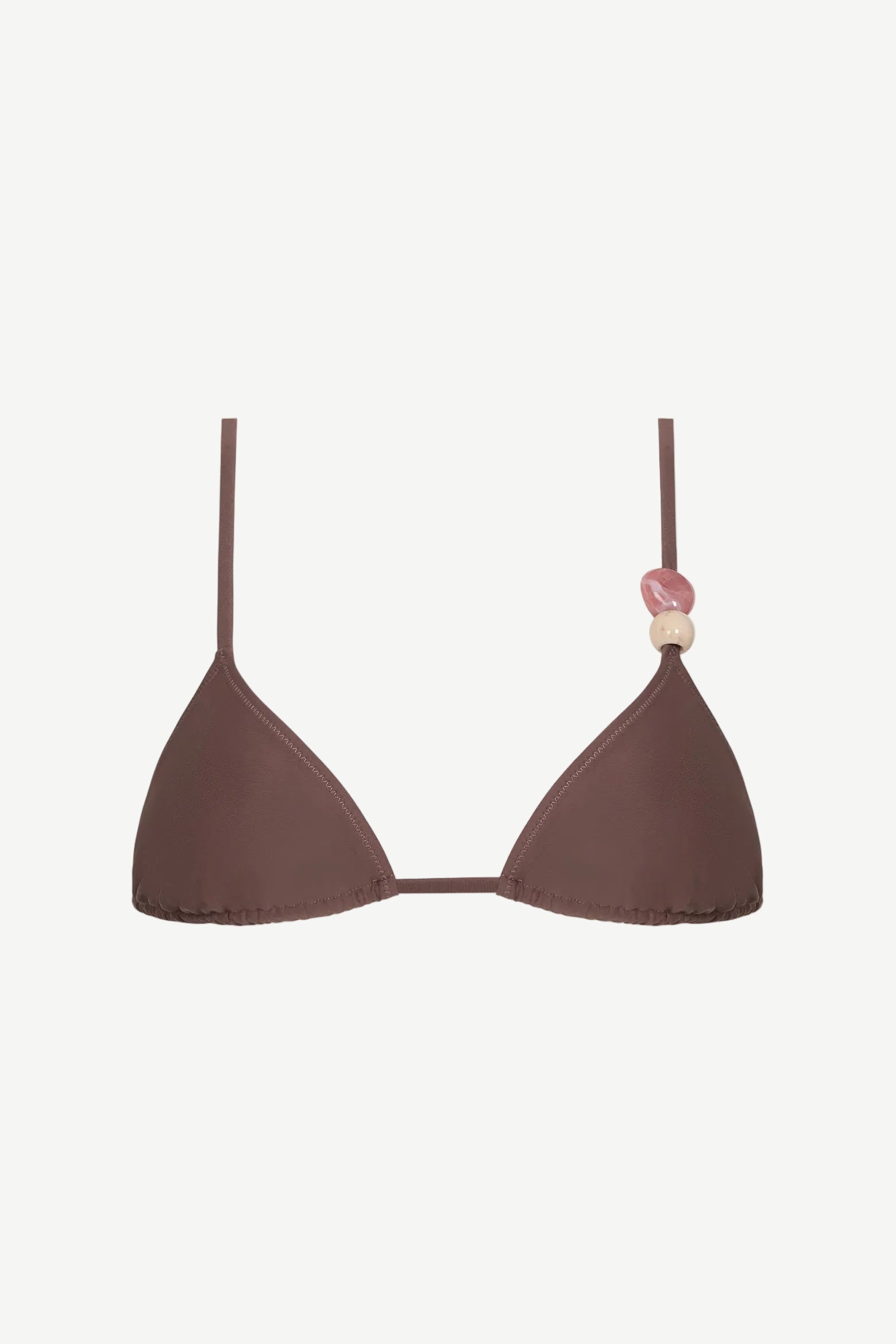 Introducing the Equator Top: an eco-friendly brown triangle bikini top featuring thin, adjustable straps. The left strap is adorned with three decorative beads in pink and beige tones, blending stylish design with sustainable swimwear choices.