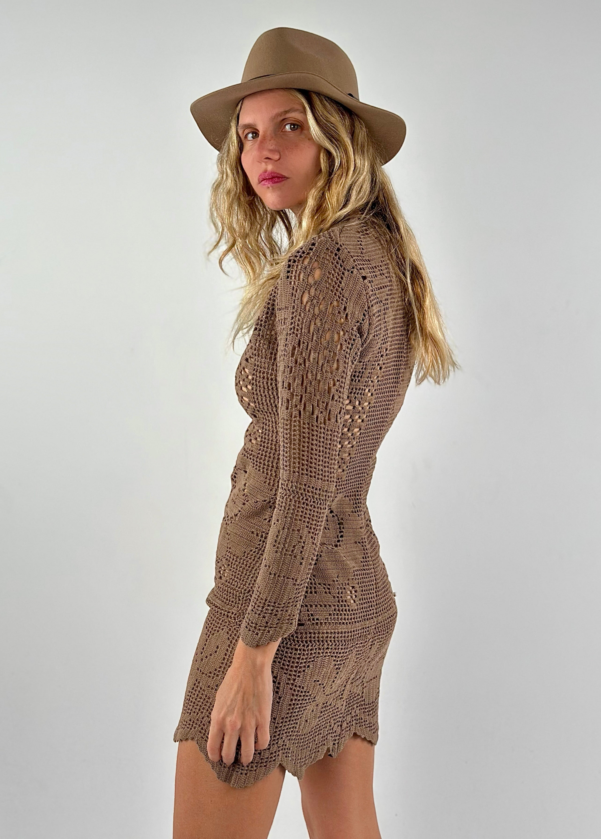 Model wearing a KABE SHOP INC long-sleeve brown crochet mini dress and a matching fedora hat against a white background