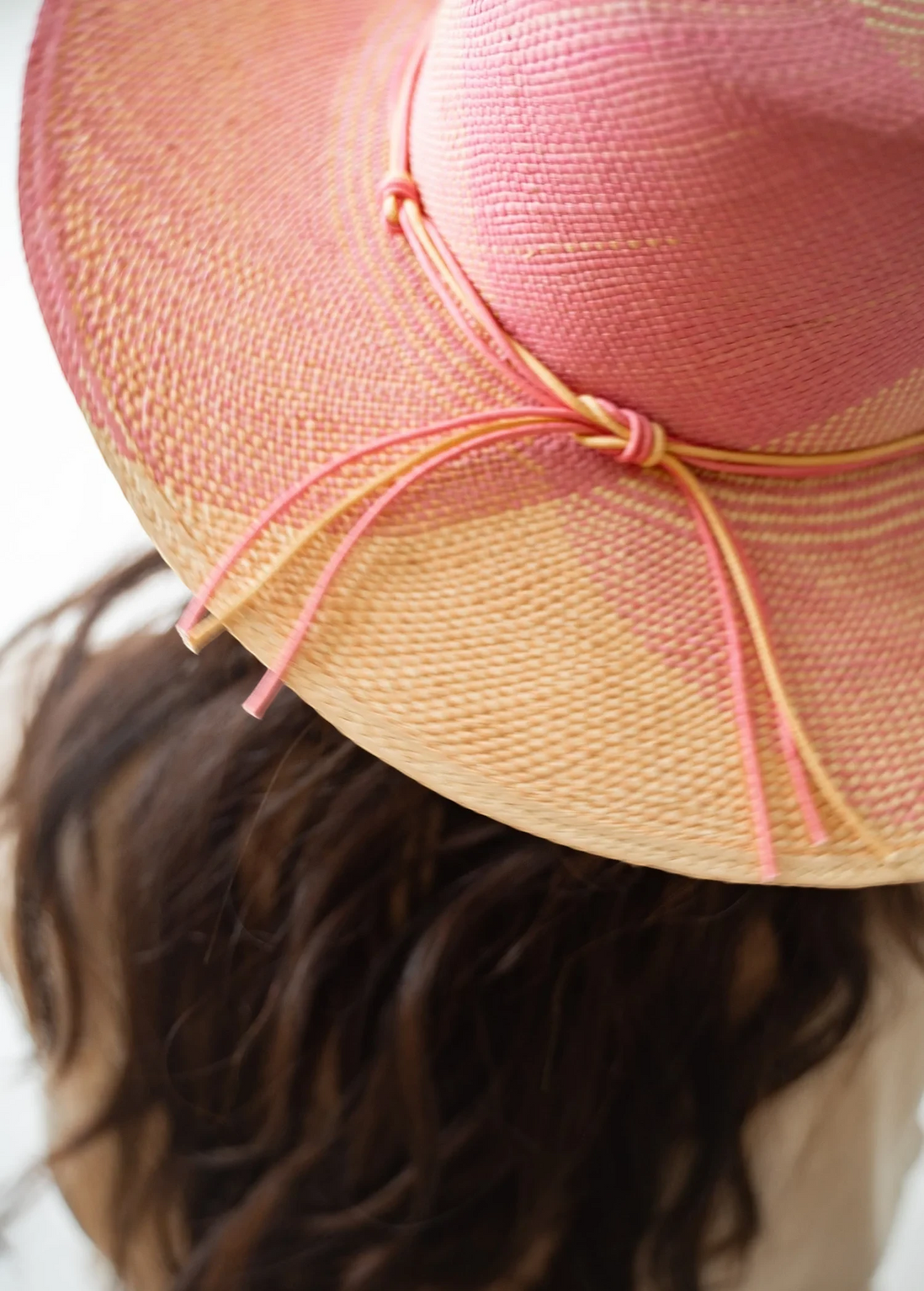 KABE SHOP INC Awisqa hat in pink and natural straw with a delicate knotted cord detail worn by a woman