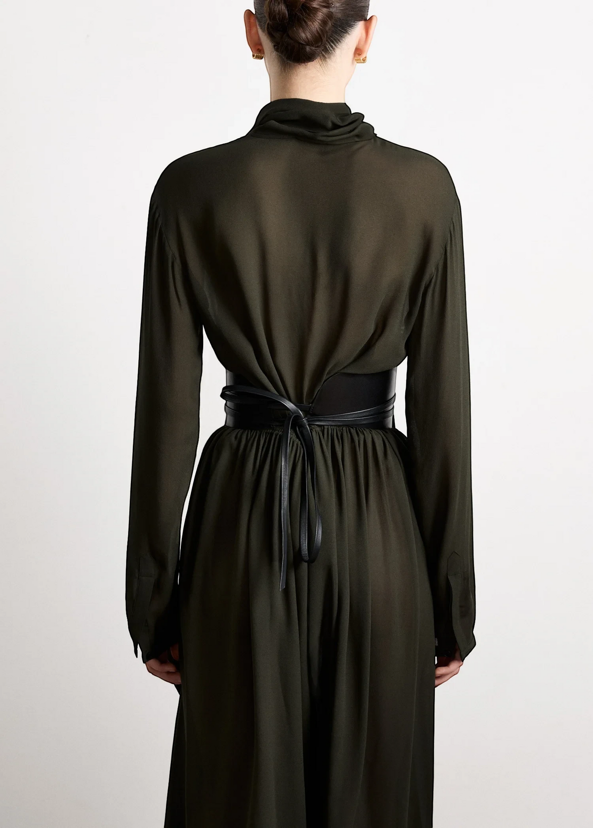 KABE SHOP INC Undone Corset Belt in black calfskin worn over a dark green dress, showing back view and tie detail.