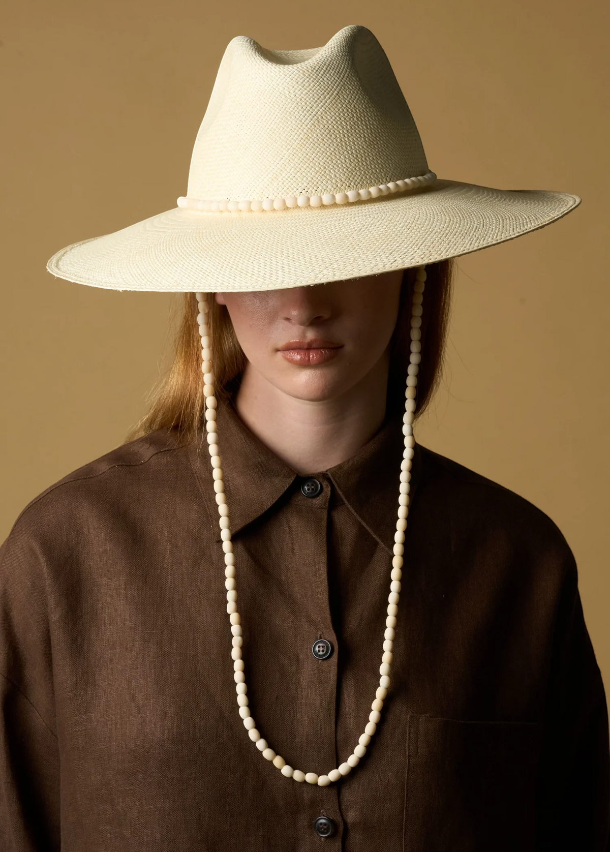 KABE SHOP INC Cajas wide brim straw hat in cream with beaded trim and matching chin strap worn by a model