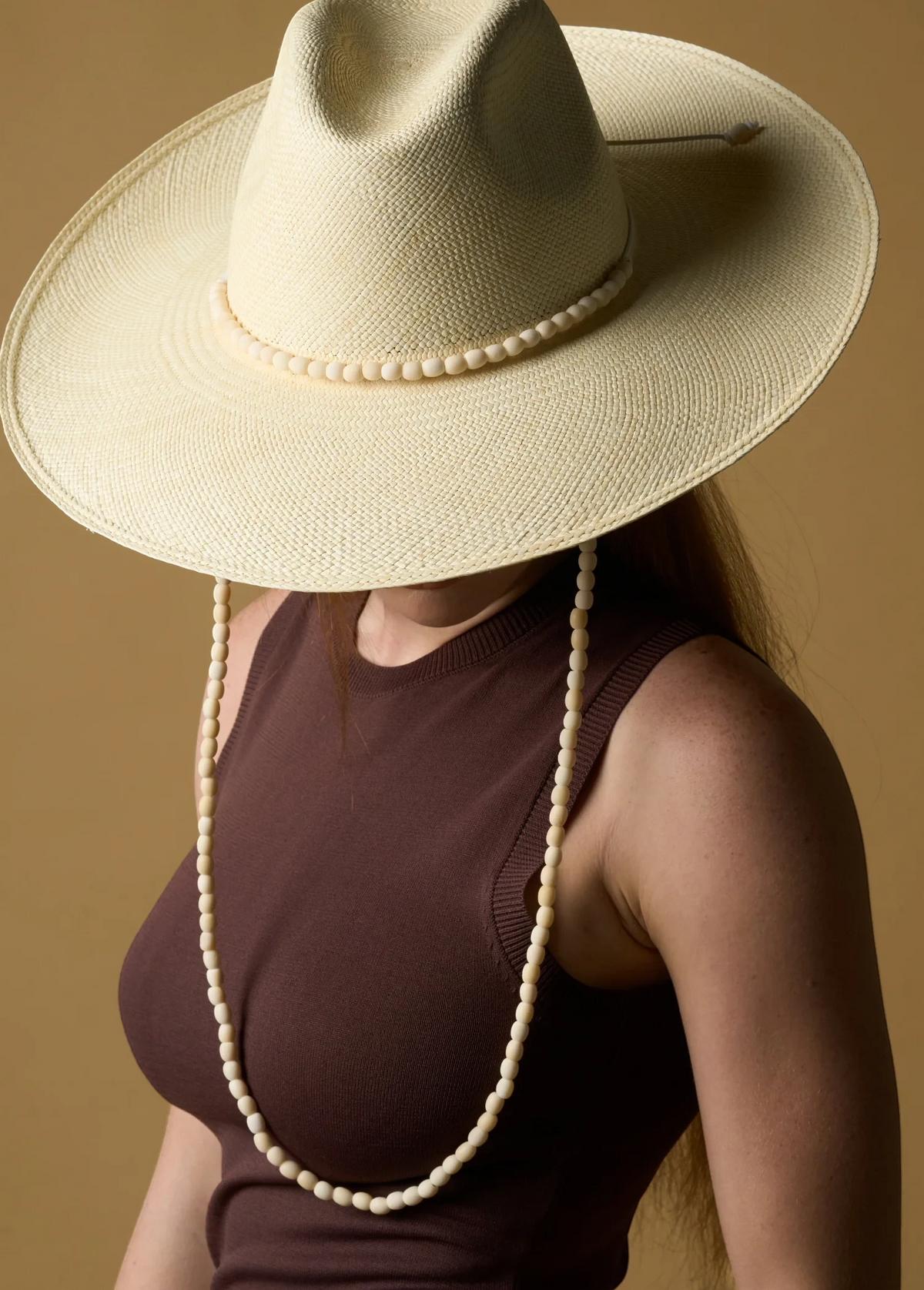 KABE SHOP INC Cajas wide brim straw hat in cream with a decorative beaded chin strap worn by a model