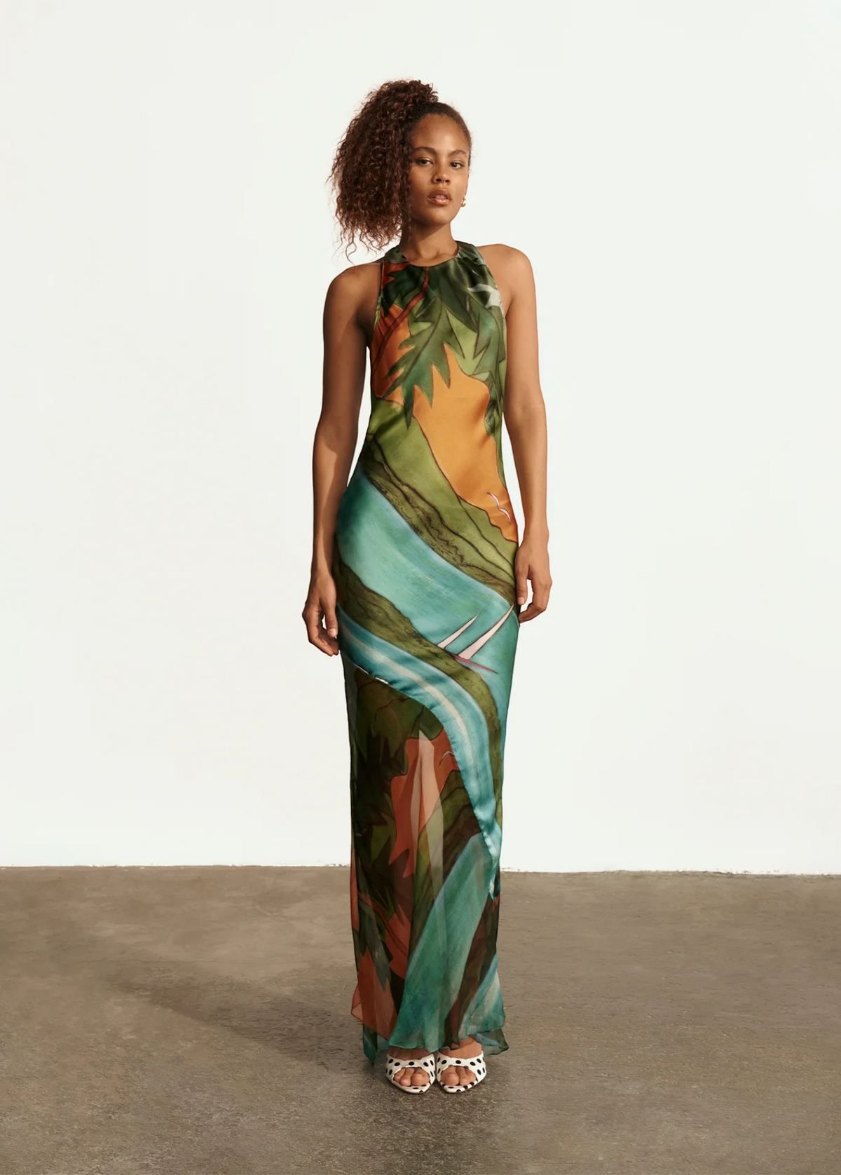 Model wearing KABE SHOP INC Magdalena long silk maxi dress with halter neckline and landscape print