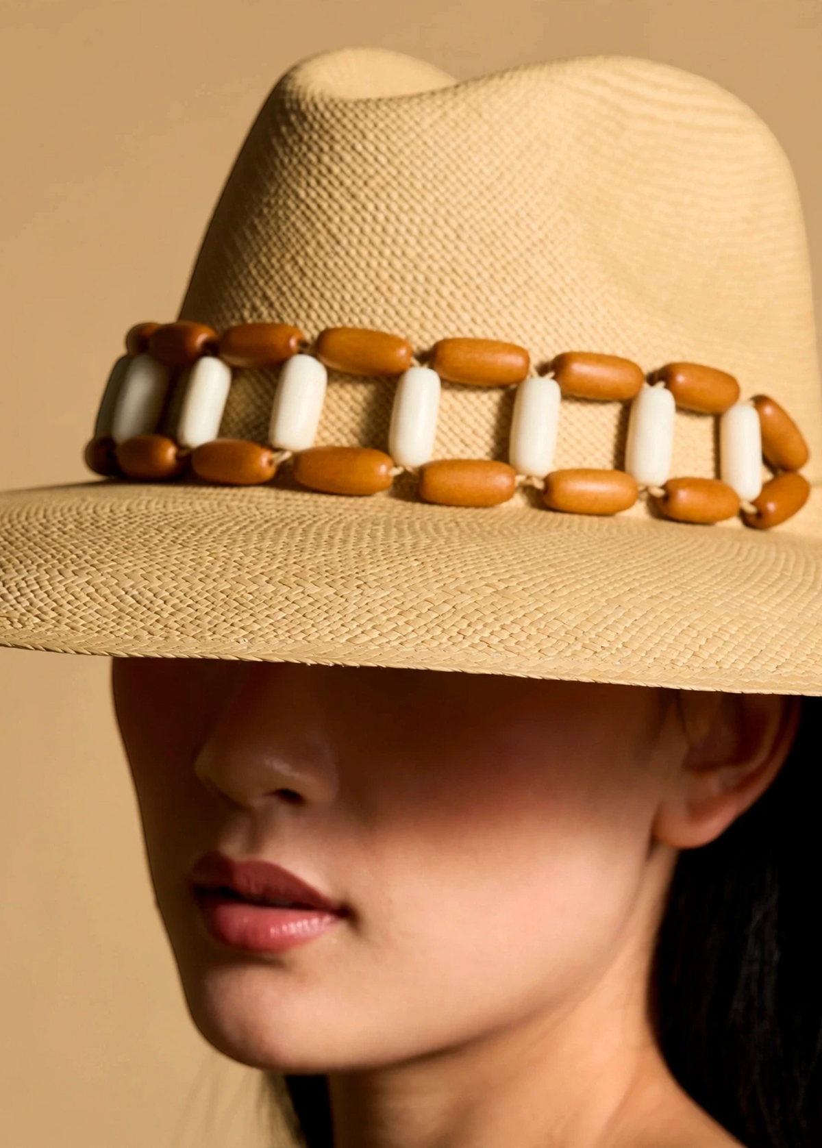 KABE SHOP INC Sine wide brim straw hat in beige with a decorative brown and white beaded band on a model
