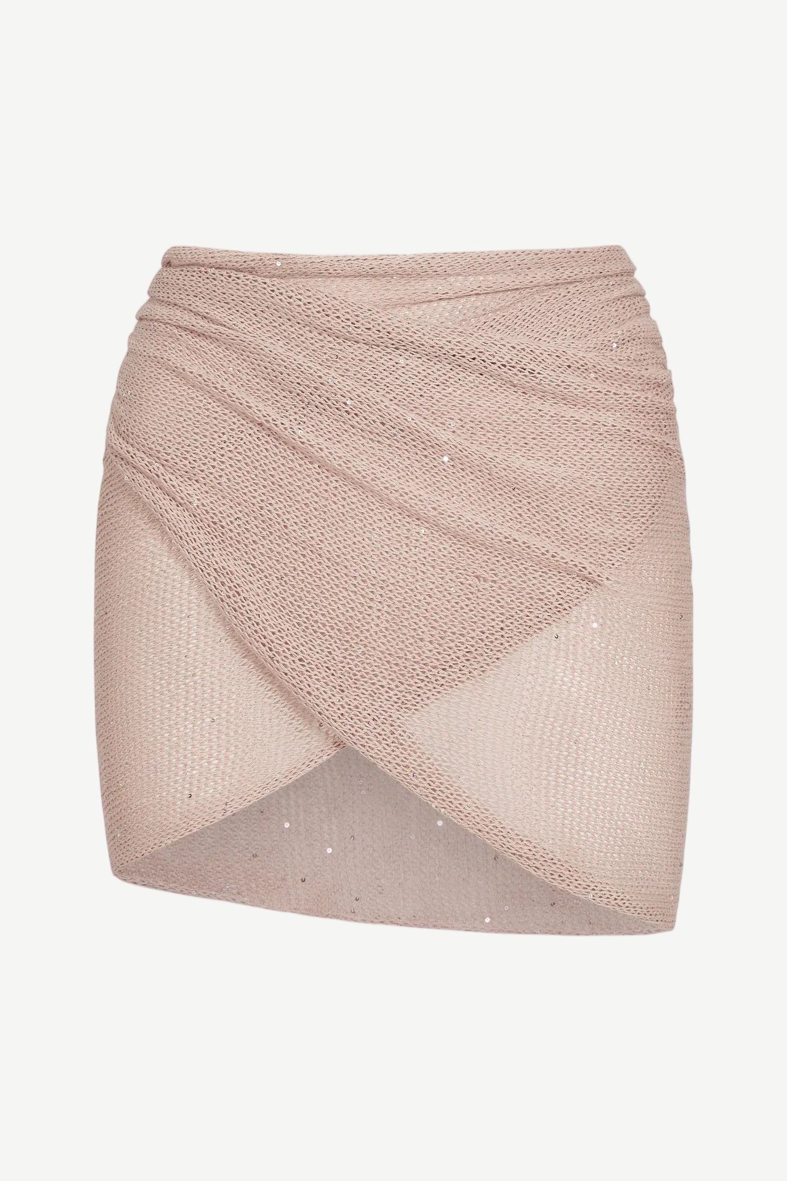 The Lumiere Skirt is a light pink, textured knit mini skirt with a criss-cross, wrap-style front and subtle sparkle details, featuring sequin bead accents for added shimmer, isolated on a white background.