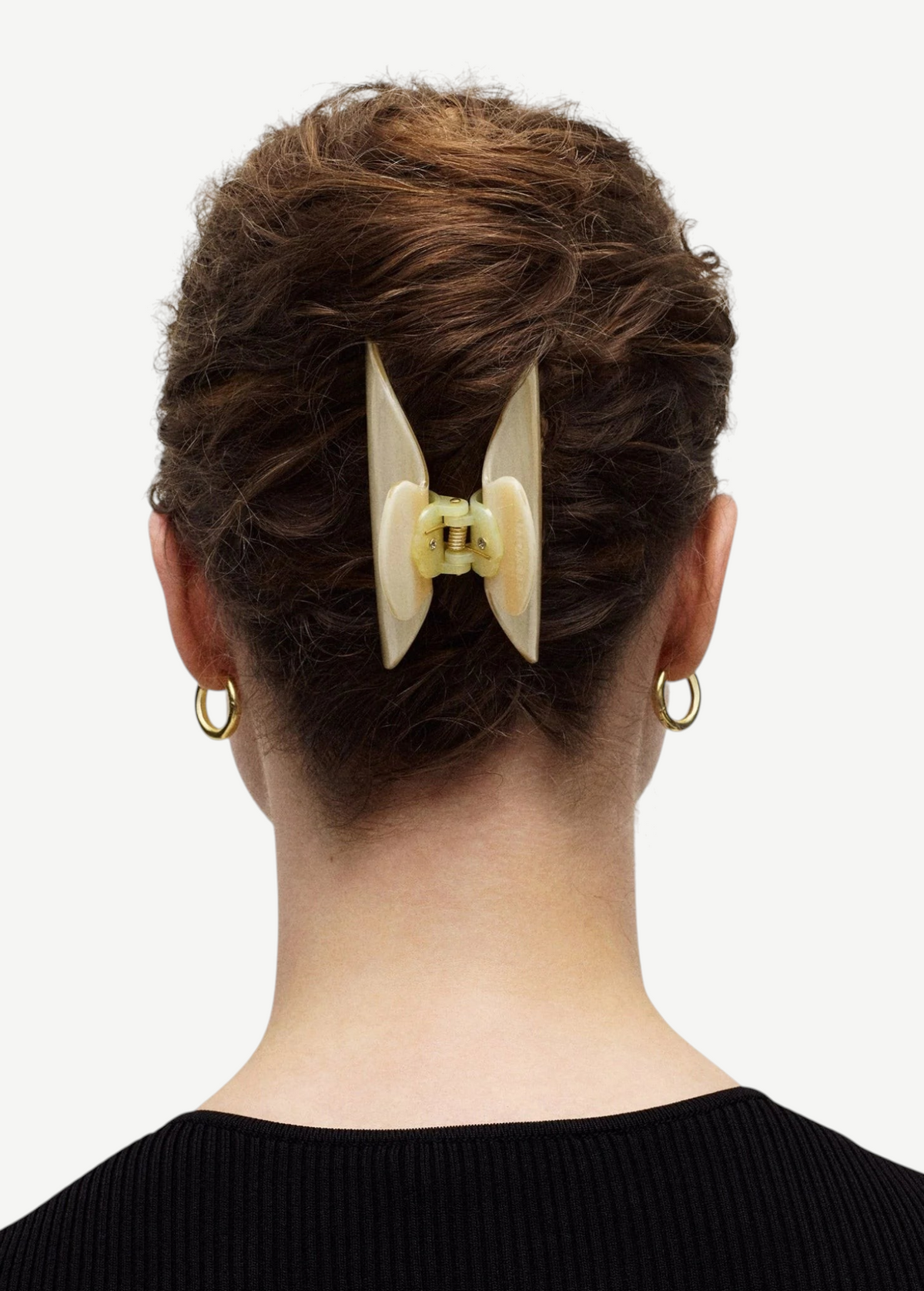 KABE SHOP INC Midi Heirloom hair claw in cream Italian acetate worn in a bun on a woman with gold hoop earrings