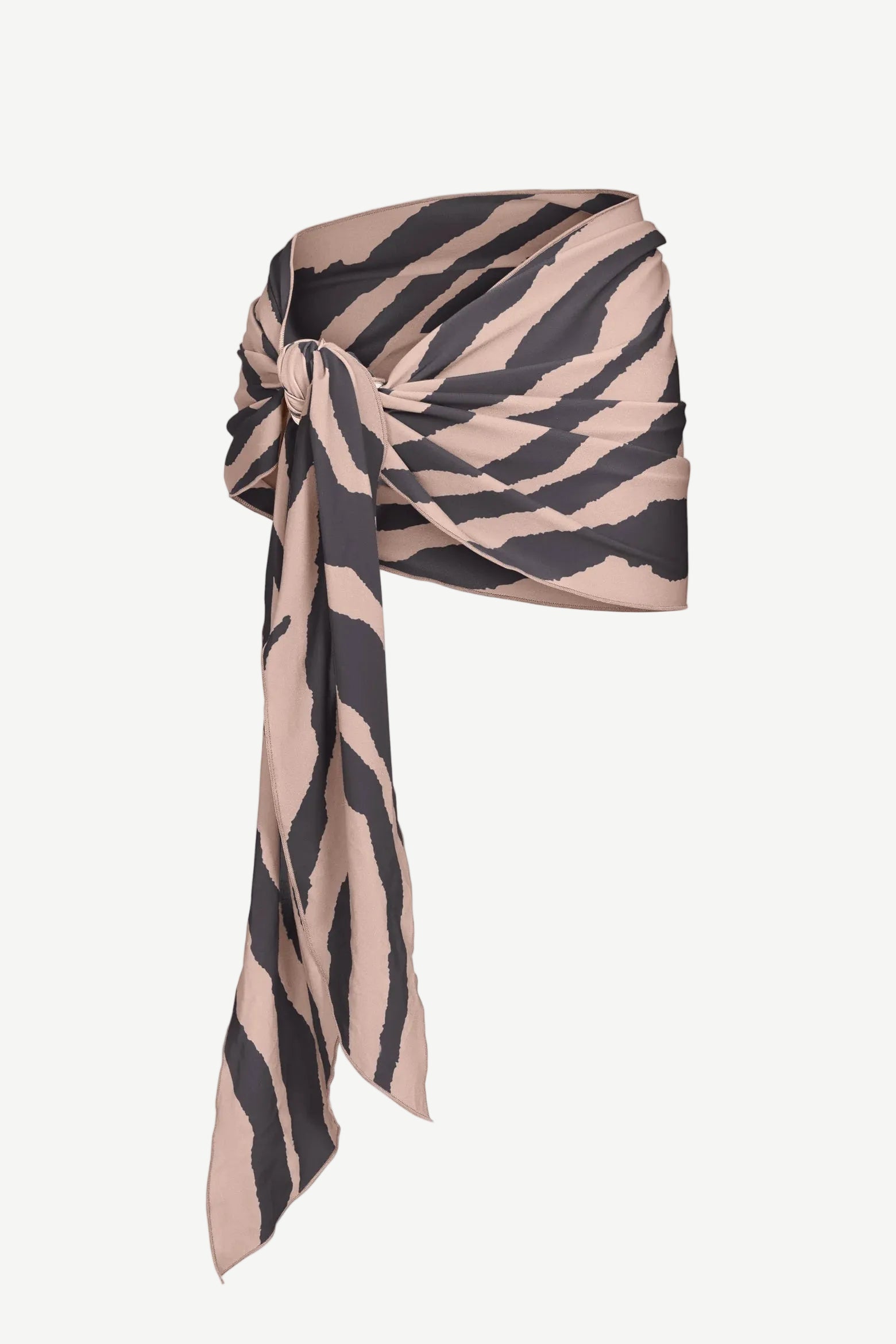 The Souk Skirt, featuring beige and black stripes, is wrapped and knotted at the waist as it drapes elegantly to one side against a plain white background.