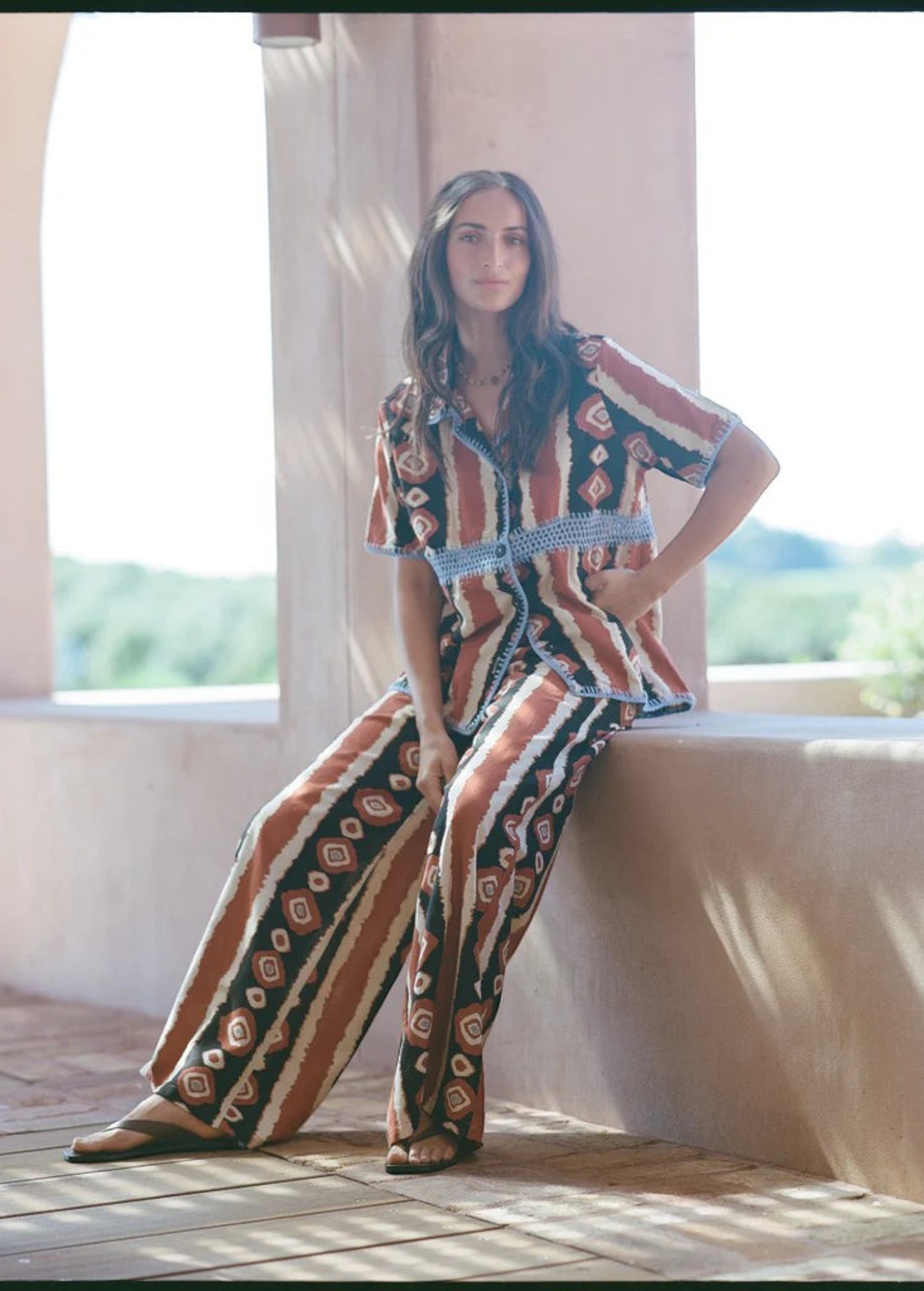 KABE SHOP INC Nera wide leg pants featuring a tribal ikat print in brown and cream tones worn with a matching shirt.