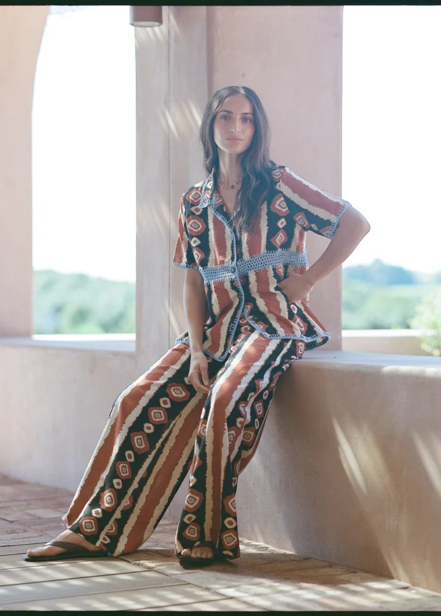 KABE SHOP INC Nera shirt featuring a brown and white ikat print with blue crochet trim in a relaxed vacation style.