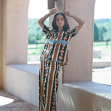 KABE SHOP INC Nera shirt featuring an oversized ikat print with crochet details, worn with matching wide-leg trousers.