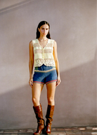 Model wearing KABE SHOP INC Nova Shorts featuring multicolored floral crochet motifs in a relaxed vacation style