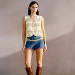 Model wearing a KABE SHOP INC Eva Vest, a cream-colored artisanal crochet button-down top with intricate detailing.