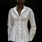 A person wears a white long-sleeve Laced Button Down featuring corset-style lace-up detailing at the waist to create a feminine silhouette.