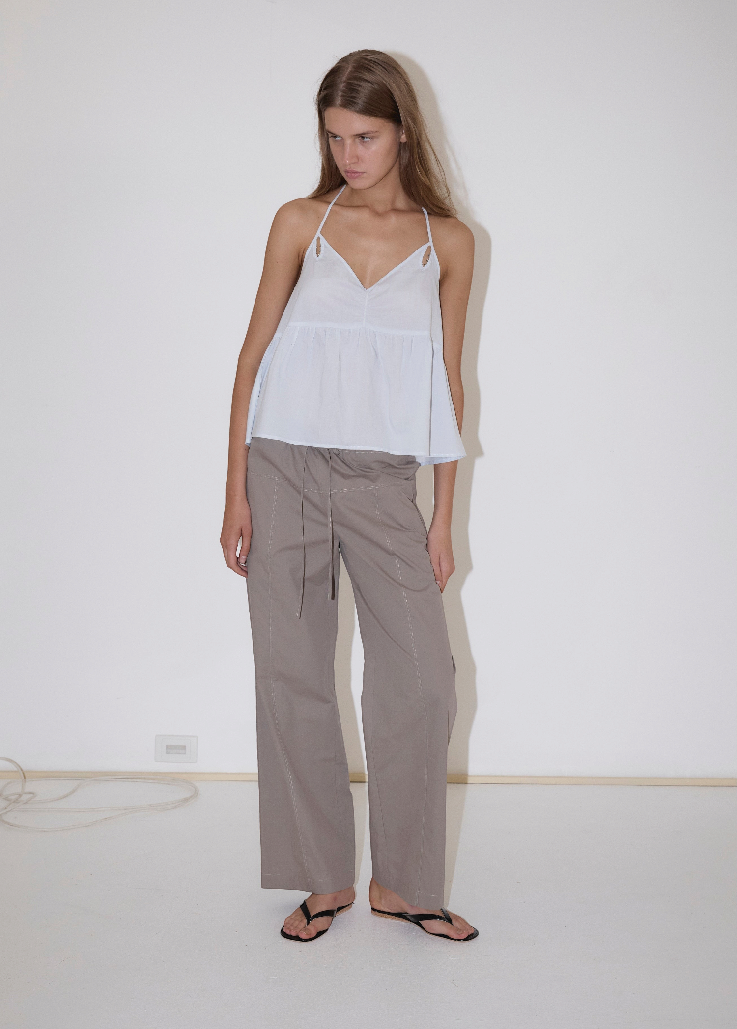 KABE SHOP INC white keyhole halter top with gathered bust and fine straps worn by a model with grey trousers