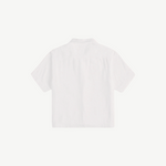 Back view of the white, short-sleeved Boxy Shirt Crochet in organic cotton, featuring a cropped, boxy fit and a crochet pocket.