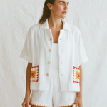 Boxy Shirt Crochet featuring an oversized white short-sleeved button-down shirt with square crochet pockets and matching shorts with a crochet hem.