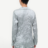 Back view of a sage green long-sleeved Suki Shirt with a crinkled texture, offering an effortless styling essential.