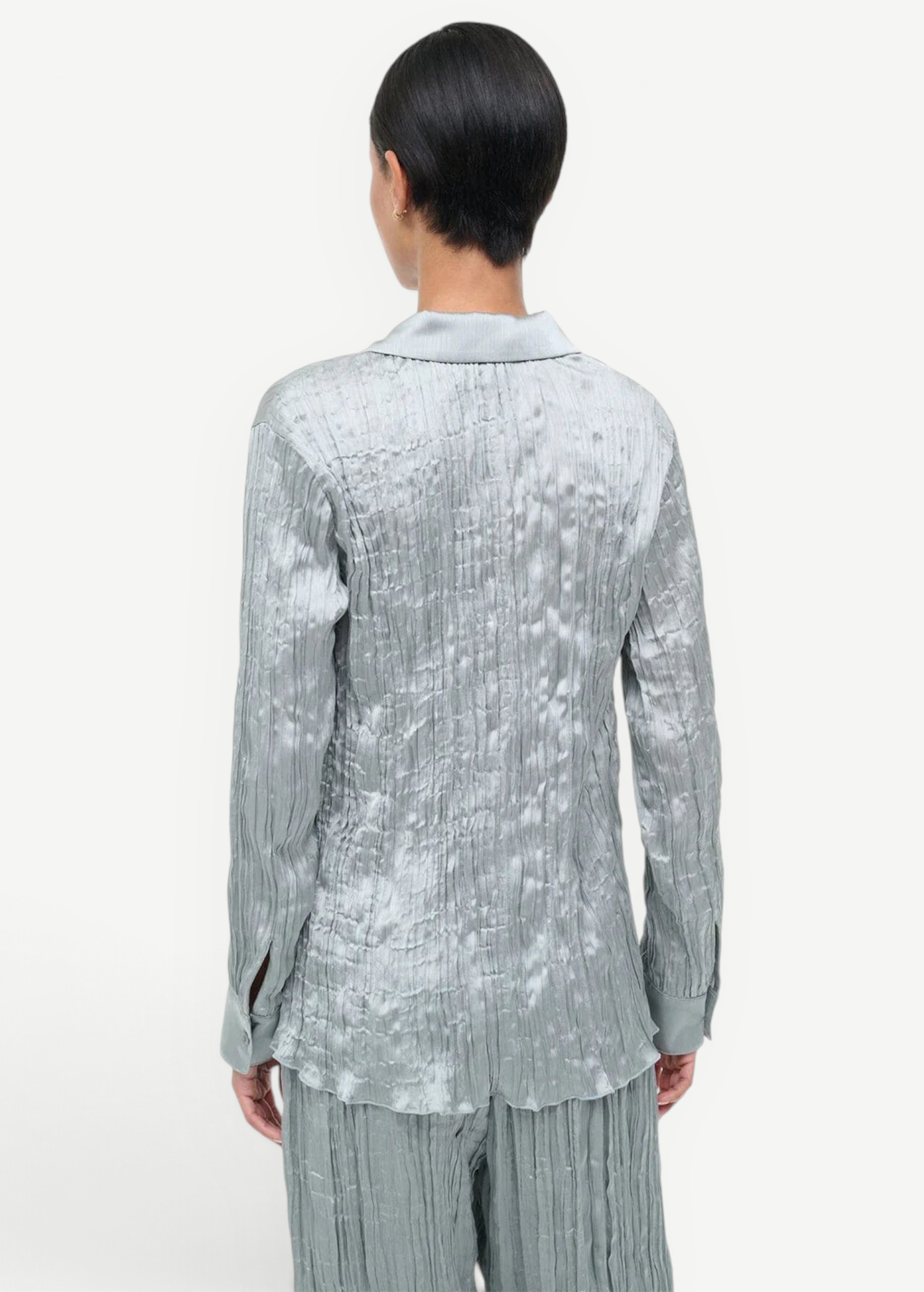 Back view of a sage green long-sleeved Suki Shirt with a crinkled texture, offering an effortless styling essential.