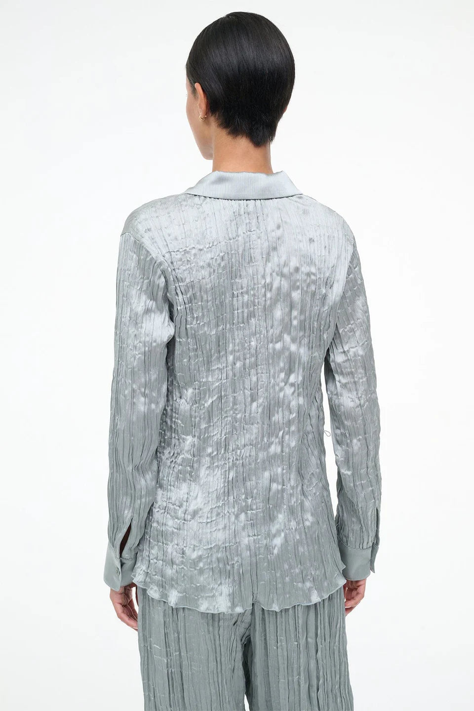 Back view of a sage green long-sleeved Suki Shirt with a crinkled texture, offering an effortless styling essential.