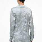 Back view of a sage green long-sleeved Suki Shirt with a crinkled texture, offering an effortless styling essential.
