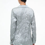 Back view of a sage green long-sleeved Suki Shirt with a crinkled texture, offering an effortless styling essential.