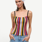 A person wearing a white headscarf and a multicolored striped Skye Tank with thin black straps.