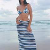 Model wearing KABE SHOP INC Geo Flower triangle bikini top and striped maxi skirt on a beach