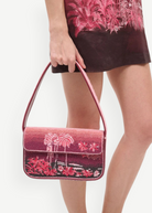KABE SHOP INC Tommy beaded shoulder bag in pink with a California-inspired palm tree print held by a model