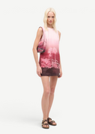 Model wearing a KABE SHOP INC Tommy beaded bag with a California-inspired print paired with a matching ombre dress