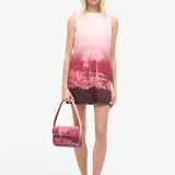 KABE SHOP INC Tommy beaded shoulder bag with pink California palm tree print held by a model in a matching dress