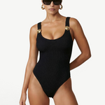 KABE SHOP INC Tita one-piece swimsuit in black textured fabric with gold button shoulder strap details on a model.