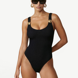 KABE SHOP INC Tita one-piece swimsuit in black textured fabric with gold button shoulder strap details on a model.