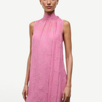 The Mini Albee Dress is a sleeveless, high-neck mini dress in pink featuring textured floral embroidery and an attached side scarf for a sophisticated silhouette.