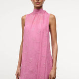 The Mini Albee Dress is a sleeveless, high-neck mini dress in pink featuring textured floral embroidery and an attached side scarf for a sophisticated silhouette.