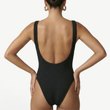 KABE SHOP INC Tita one-piece swimsuit in black with a textured fabric, scoop back, and high-cut leg design.
