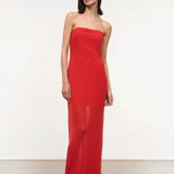 A person wearing a red, floor-length, strapless Liliana Dress with a sheer overlay.