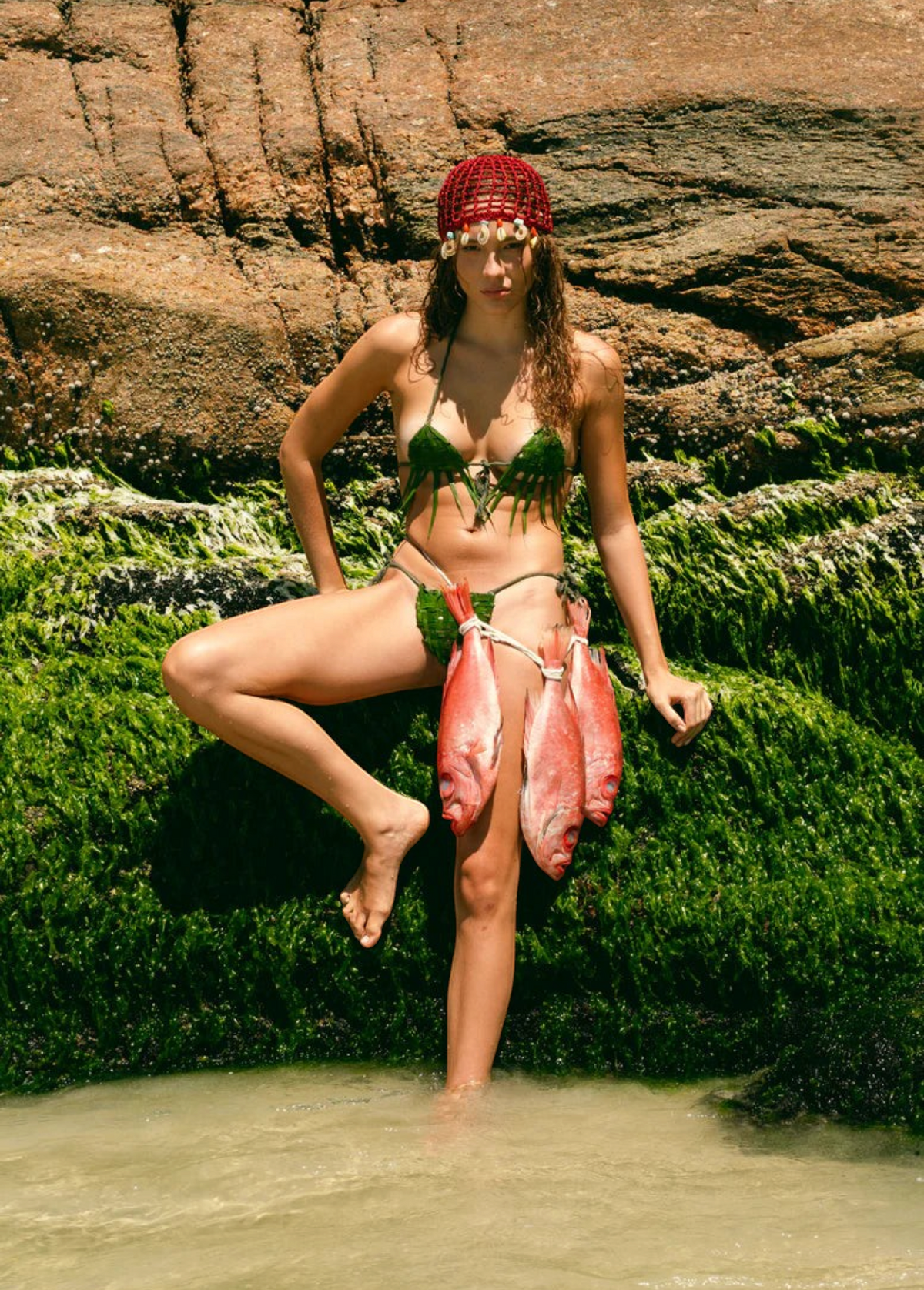 KABE SHOP INC Zahi Hat, a vibrant red artisanal skullcap with intricate shell embellishments worn by a model.