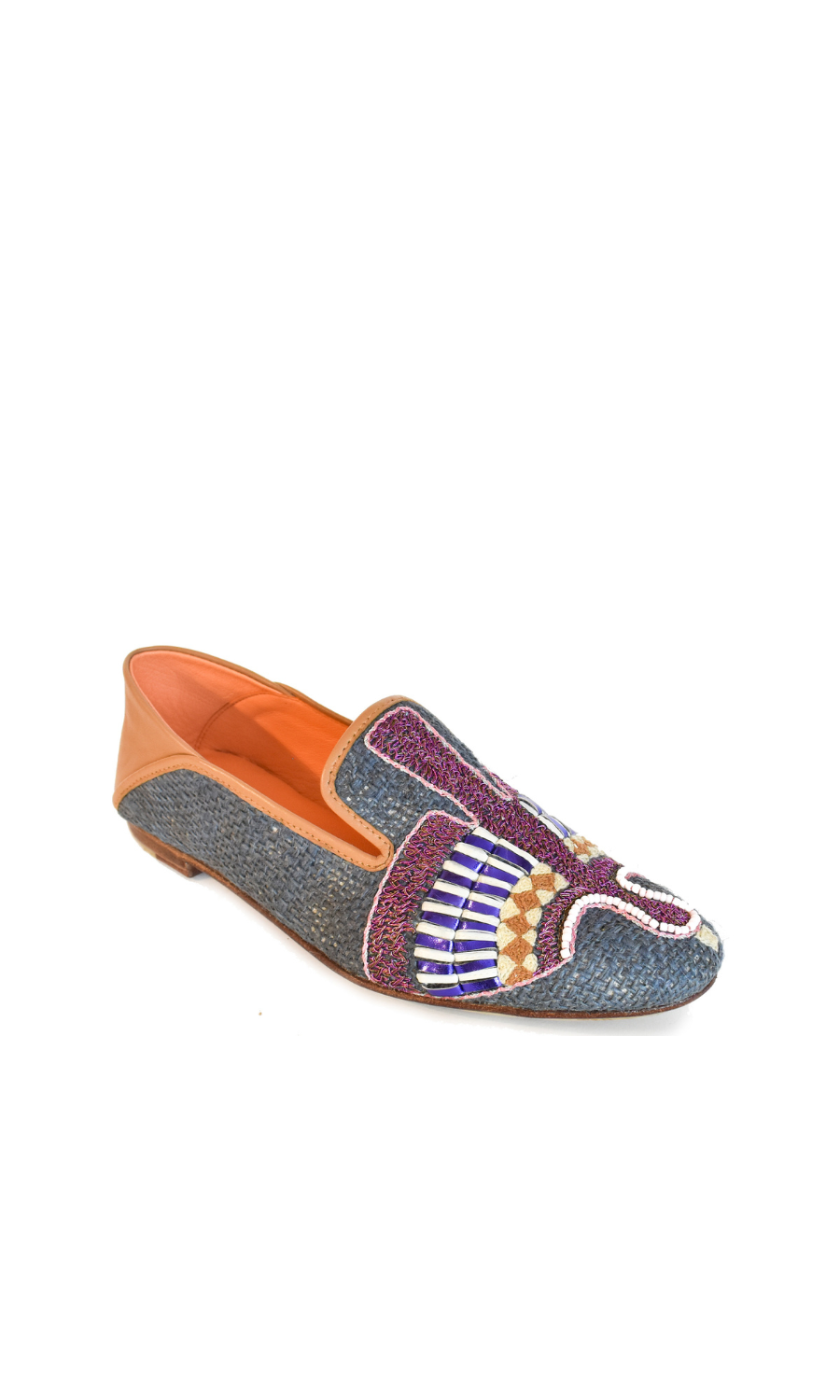 The Anzu Moccasin is a hand-embroidered leather loafer crafted with blue textured material, multicolored beaded designs on the upper, tan leather detailing at the heel, and an orange interior.
