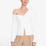 Model wearing a white KABE SHOP INC Craftsman Sweater with an asymmetrical off-the-shoulder neckline and buttons.