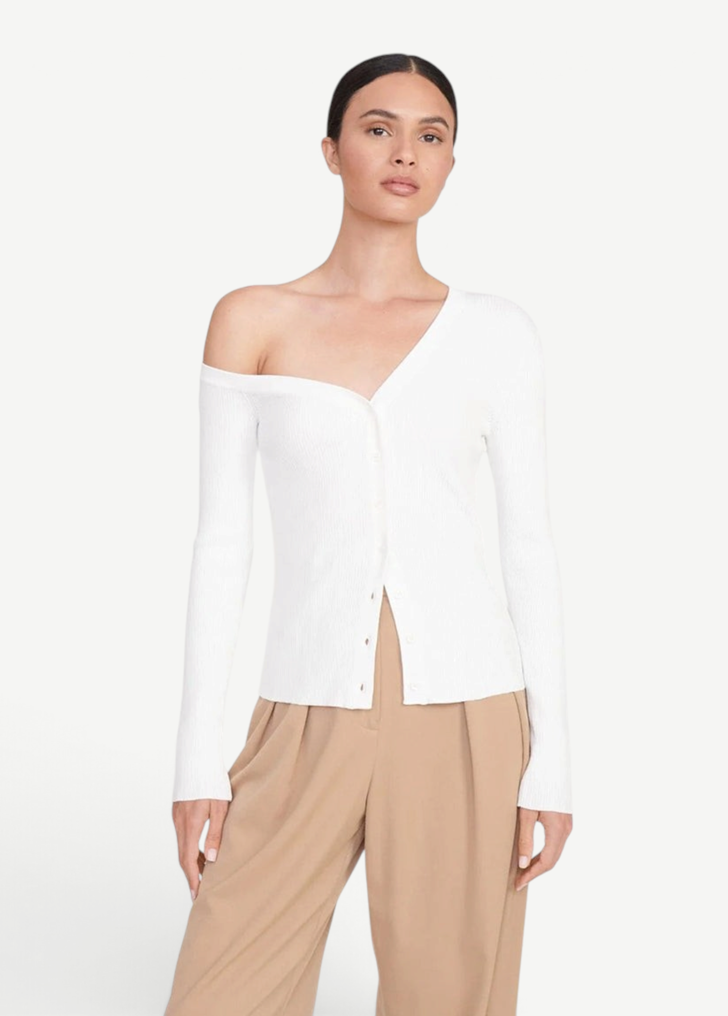 Model wearing a white KABE SHOP INC Craftsman Sweater with an asymmetrical off-the-shoulder neckline and buttons.