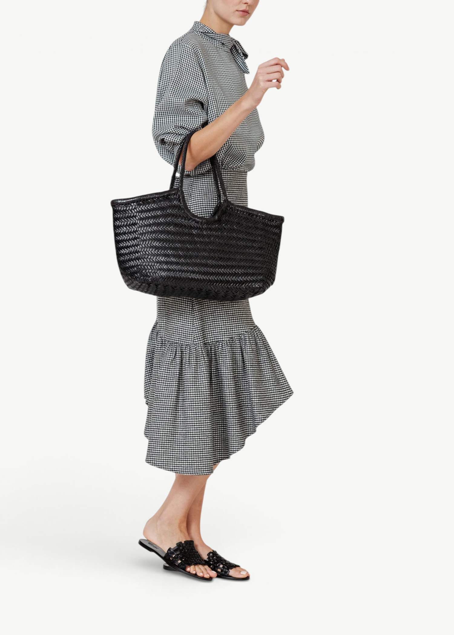 KABE SHOP INC Nantucket Basket Big black handwoven buffalo calf leather tote bag carried by a woman in a gingham dress