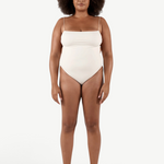 Model wearing a KABE SHOP INC cream-colored Fine Strap One Piece swimsuit with high-cut legs and delicate straps.