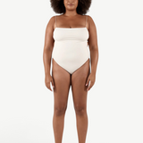 Model wearing a KABE SHOP INC cream-colored Fine Strap One Piece swimsuit with high-cut legs and delicate straps.
