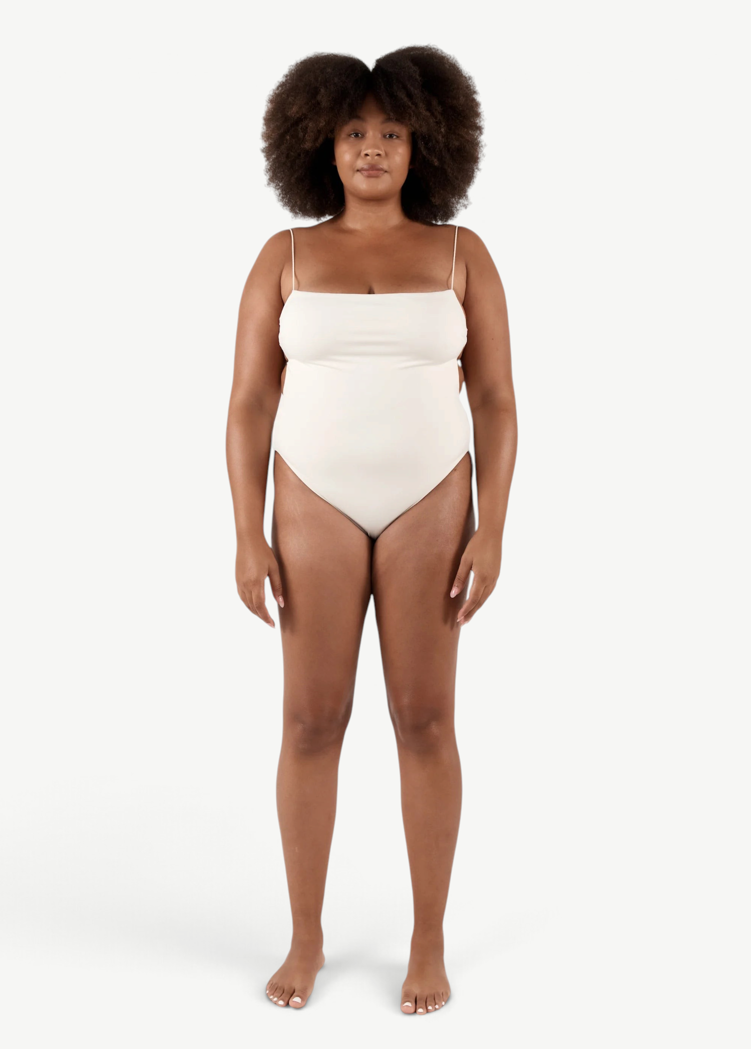 Model wearing a KABE SHOP INC cream-colored Fine Strap One Piece swimsuit with high-cut legs and delicate straps.