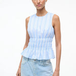 Culver Top in a light blue and white striped sleeveless peplum style with a smocked waist for a feminine silhouette.